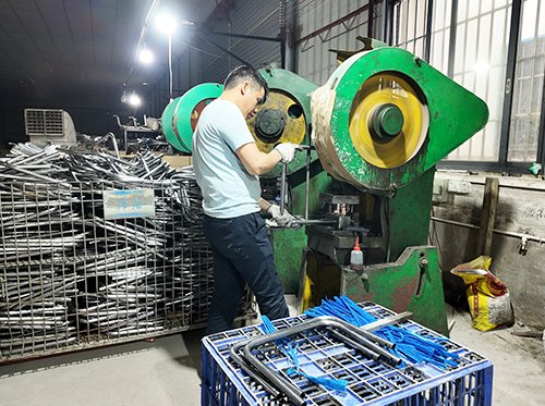 A skilled worker using a specialized manual cutting saw to make a precise angled cut on an aluminum profile.